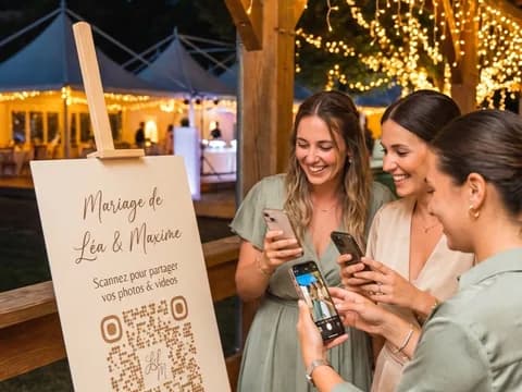 Deux invitées scannent avec leur téléphone un QR code posé sur un chevalet à l'entrée de la réception