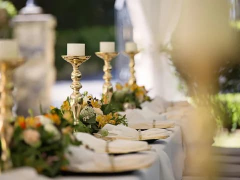 Table de réception dressée avec bougies et compositions florales