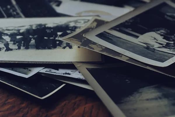 Des tirages photo anciens empilés en désordre sur une table