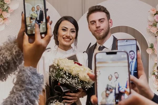 Des invités photographient les mariés avec leurs téléphones